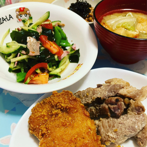 「ひとりクリスマスイブにファミチキ・前日の残りの豚肩ロースしょうが炒め・わかめの入った野菜サラダ・白菜とお揚げの味噌汁・納豆にしそ昆布」の写真